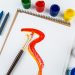 Top view of art album pages, brushes and drawing crayons